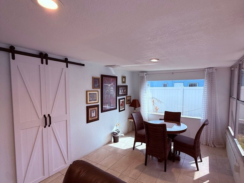 Cleaned dining area with a sliding barn door, tiled floor and dusted decor