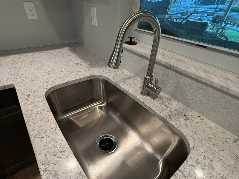 New kitchen with a stainless undermount sink and marble countertops cleaned after construction