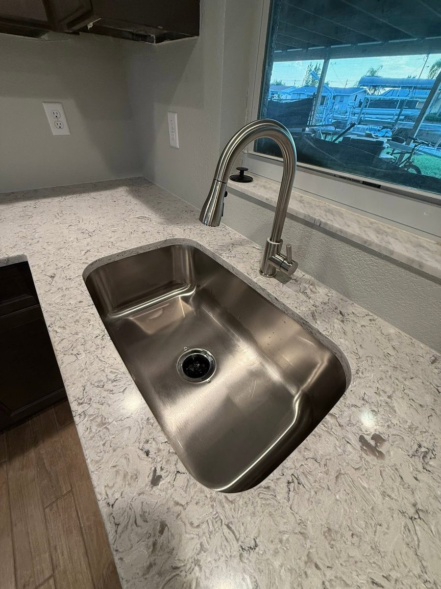 New kitchen with a stainless undermount sink and marble countertops cleaned after construction