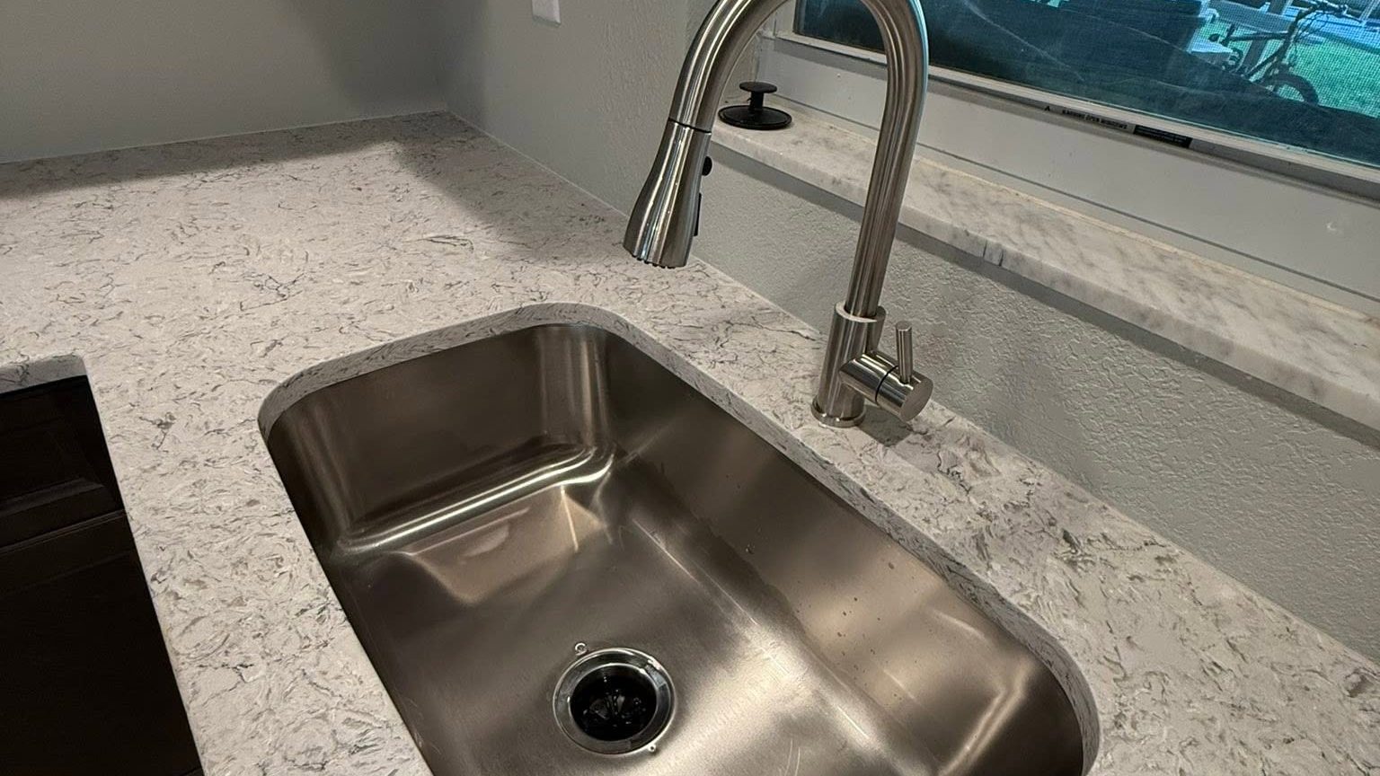 New kitchen with a stainless undermount sink and marble countertops cleaned after construction