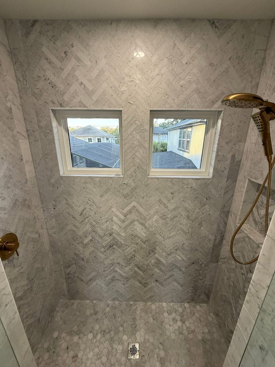 Herringbone tiled walk-in shower scrubbed clean with the grout lines detailed