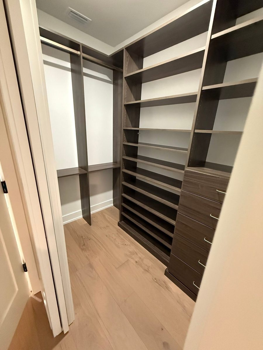 Walk-in closet with built-in shelving wiped down and floors vacuumed